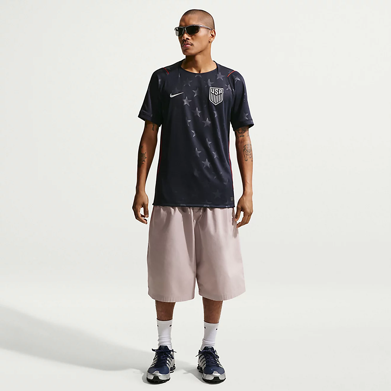 Men wearing Nike USA 2026 World Cup away jersey with beige shorts and sneakers, modern soccer streetwear outfit for casual summer fashion